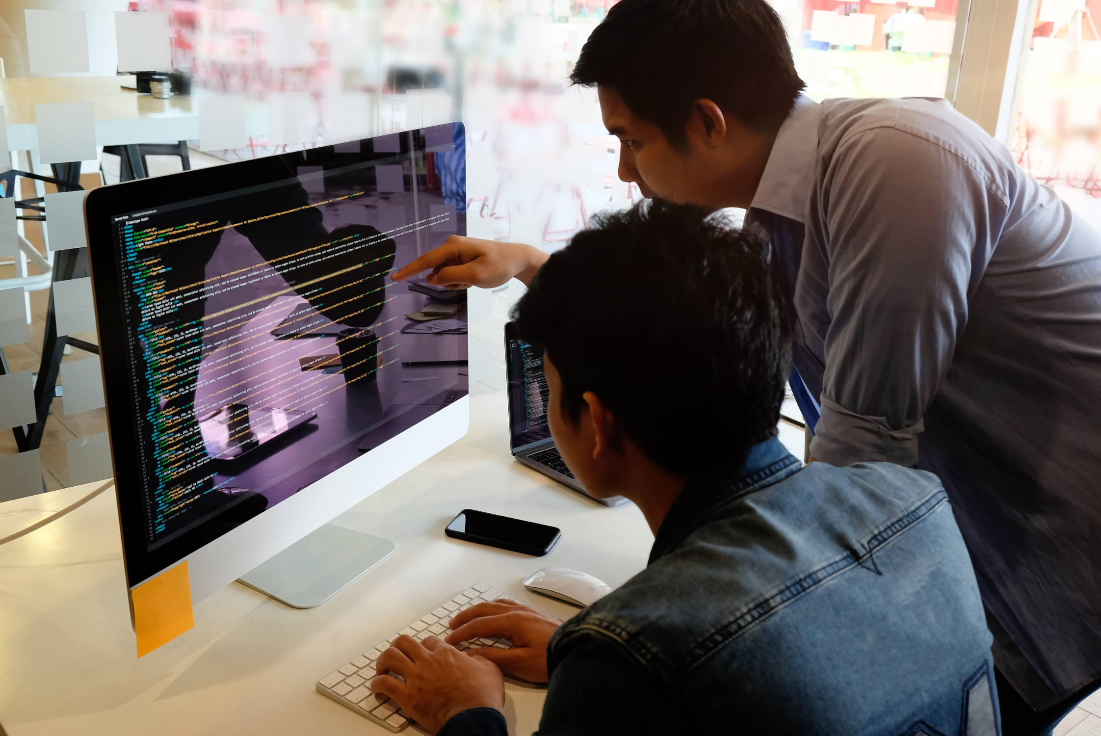 programmer-team-working-computer-coding-software-development Asian female checking phone